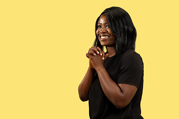 Image showing Young african woman isolated on yellow studio background, facial expression