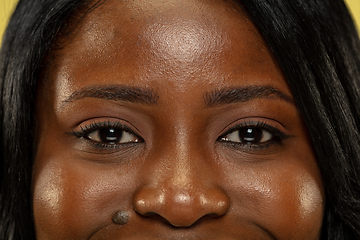 Image showing Young african woman isolated on yellow studio background, facial expression