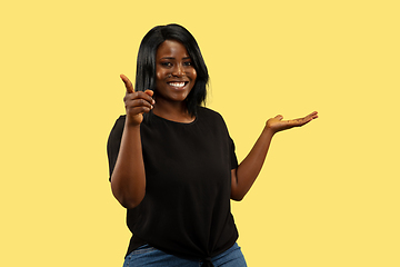 Image showing Young african woman isolated on yellow studio background, facial expression