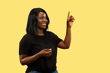 Image showing Young african woman isolated on yellow studio background, facial expression