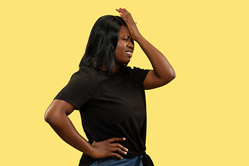 Image showing Young african woman isolated on yellow studio background, facial expression