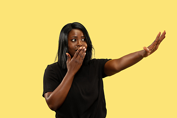 Image showing Young african woman isolated on yellow studio background, facial expression