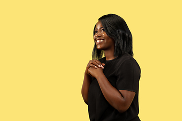 Image showing Young african woman isolated on yellow studio background, facial expression