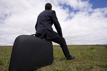 Image showing businessman sit in his baggage 