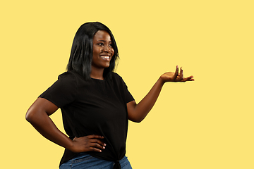 Image showing Young african woman isolated on yellow studio background, facial expression