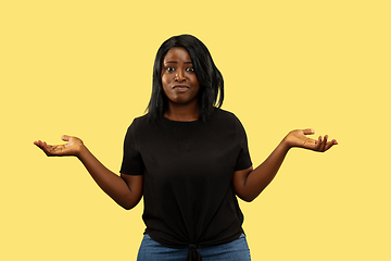 Image showing Young african woman isolated on yellow studio background, facial expression