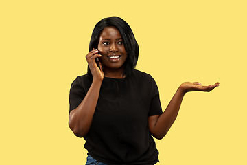 Image showing Young african woman isolated on yellow studio background, facial expression