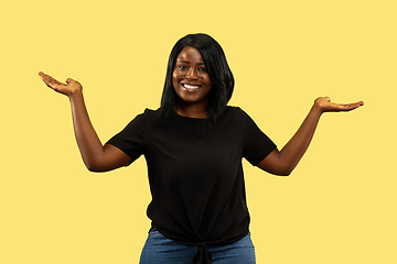 Image showing Young african woman isolated on yellow studio background, facial expression