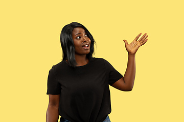 Image showing Young african woman isolated on yellow studio background, facial expression