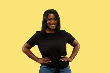 Image showing Young african woman isolated on yellow studio background, facial expression