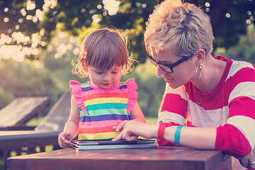 Image showing mom and her little daughter using tablet computer