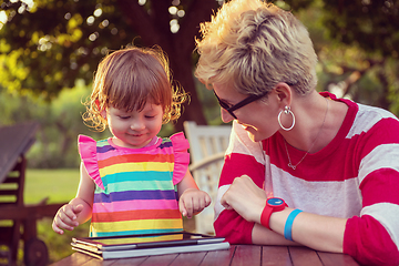 Image showing mom and her little daughter using tablet computer