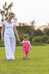 Image showing mother and little daughter playing at backyard