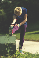 Image showing female runner warming up and stretching