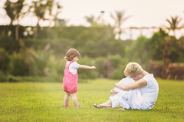 Image showing mother and little daughter playing at backyard