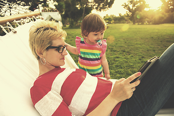 Image showing mom and a little daughter relaxing in a hammock