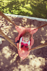 Image showing little girl swinging  on a playground