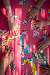 Image showing top view of kids hands playing with puzzles