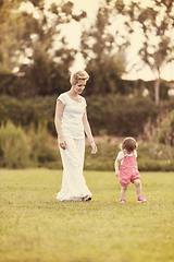 Image showing mother and little daughter playing at backyard