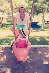 Image showing mother and daughter swinging in the park