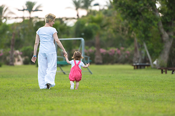 Image showing mother and little daughter playing at backyard