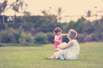 Image showing mother and little daughter playing at backyard