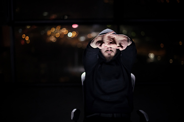 Image showing hacker using laptop computer while working in dark office