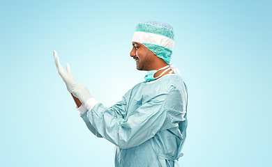 Image showing indian male doctor or surgeon putting glove on