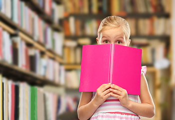 Image showing little girl hiding over book at library