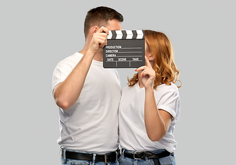 Image showing happy couple in white t-shirts with clapperboard