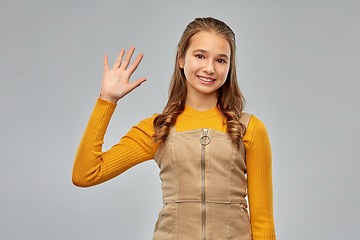 Image showing happy smiling young teenage girl waving hand