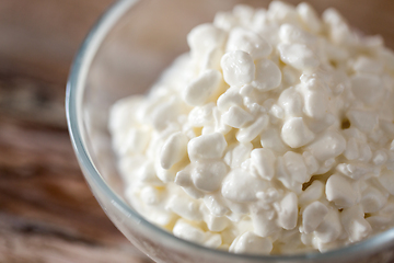 Image showing close up of cottage cheese in bowl on wooden table