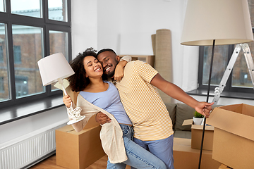 Image showing happy couple packing boxes and moving to new home