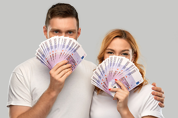 Image showing happy couple in white t-shirts with euro money