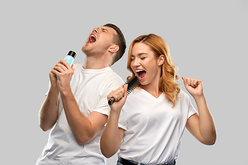 Image showing happy couple singing to hairbrush and lotion