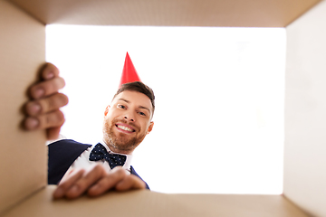 Image showing happy young man looking into open birthday gift