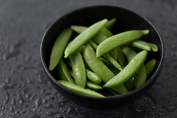 Image showing peas in bowl on wet slate stone background