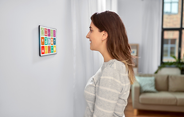 Image showing woman looking at tablet computer at smart home