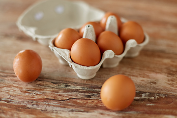 Image showing close up of eggs in cardboard box on wooden table