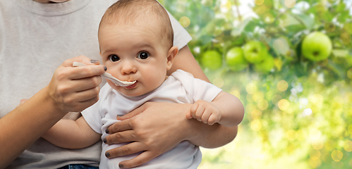 Image showing close up of mother with spoon feeding little baby