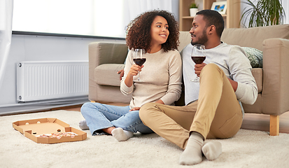 Image showing happy couple with wine and takeaway pizza at home