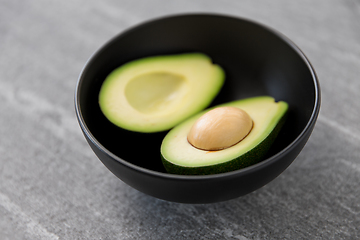 Image showing close up of ripe avocado with bone in ceramic bowl