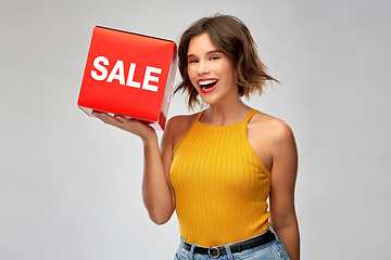 Image showing happy smiling young woman posing with sale sign