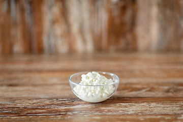 Image showing close up of cottage cheese in bowl on wooden table