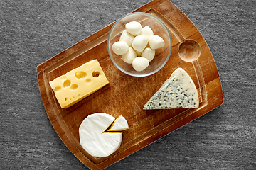 Image showing different kinds of cheese on wooden cutting board