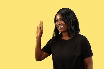 Image showing Young african woman isolated on yellow studio background, facial expression