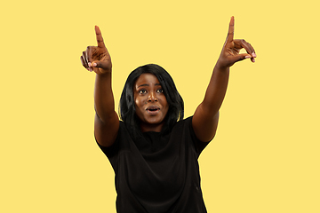 Image showing Young african woman isolated on yellow studio background, facial expression