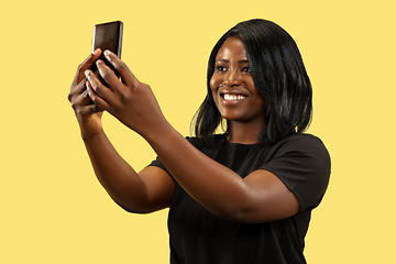 Image showing Young african woman isolated on yellow studio background, facial expression