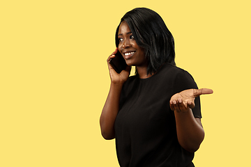 Image showing Young african woman isolated on yellow studio background, facial expression