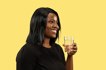 Image showing Young african woman isolated on yellow studio background, facial expression